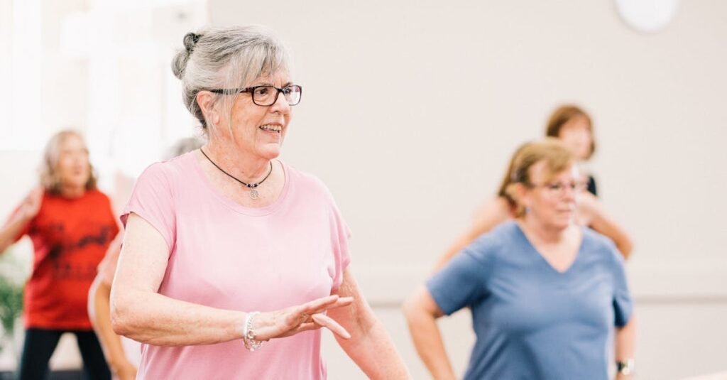 Senior women participating in a lively and joyful group exercise session indoors.